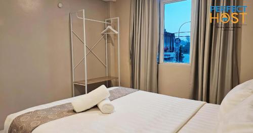 a bedroom with a bed and a window at Triima Inn Dayang Bay by Perfect Host in Kuah