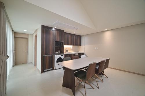 a kitchen with a table and chairs in a room at Masion Sanbang Jeju in Seogwipo