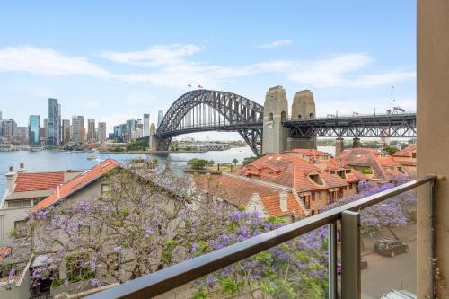 a view of the sydney harbour bridge with purple flowers at Boutique 2-Bed with Stunning Sydney Harbour Views in Sydney