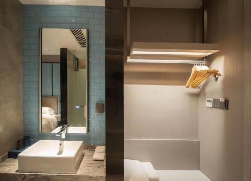 a bathroom with a sink and a mirror at Echarm Hotel Changsha Wuyi Square Xiangya Affiliated 1st Provincial Maternity and Child in Changsha