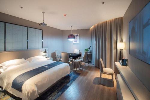 a bedroom with a large bed and a desk with a computer at Echarm Hotel Changsha Wuyi Square Xiangya Affiliated 1st Provincial Maternity and Child in Changsha