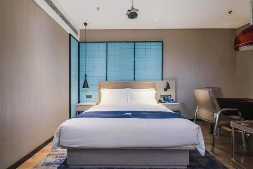 a bedroom with a bed and a desk and a window at Echarm Hotel Changsha Wuyi Square Xiangya Affiliated 1st Provincial Maternity and Child in Changsha