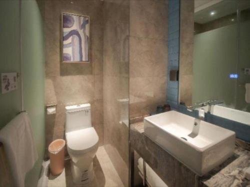 a bathroom with a white toilet and a sink at Echarm Hotel Changsha Wuyi Square Xiangya Affiliated 1st Provincial Maternity and Child in Changsha