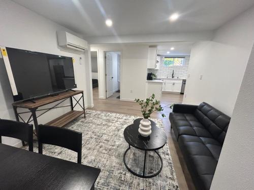 a living room with a couch and a tv and a table at 2 bedrooms near Downtown, Airport, stadiums, light rail in Seattle