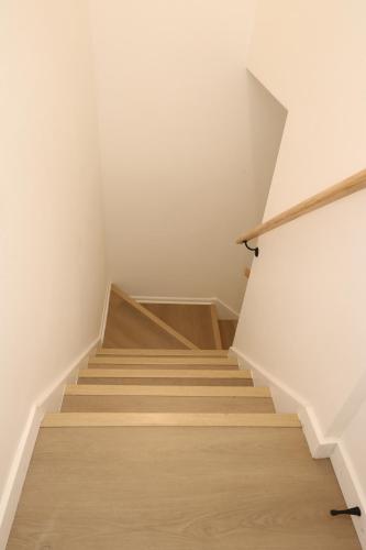 a staircase in a room with white walls and wooden floors at 2 bedrooms near Downtown, Airport, stadiums, light rail in Seattle