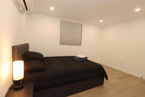 a bedroom with a black bed and a window at 2 bedrooms near Downtown, Airport, stadiums, light rail in Seattle