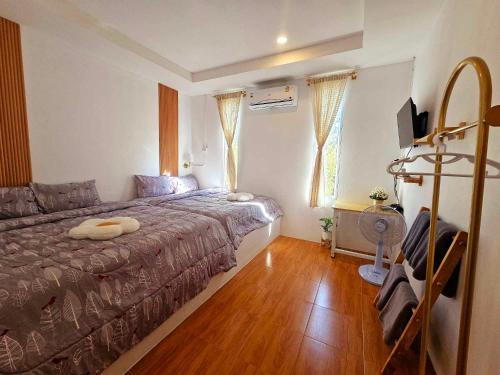 a bedroom with a bed and a wooden floor at Baan suan khun ta บ้านพักสวนคุณตา in Ko Chang