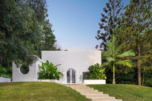 a white house with stairs and grass at Casa Campana By Khove in Clothiers Creek