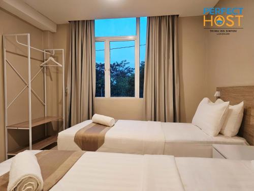 a hotel room with two beds and a window at Triima Inn Dayang Bay by Perfect Host in Kuah