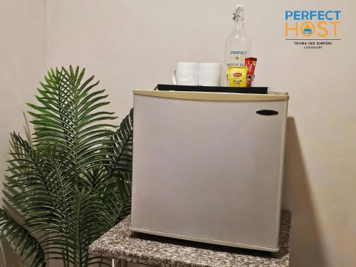 a small refrigerator with a bottle on top of it at Triima Inn Dayang Bay by Perfect Host in Kuah
