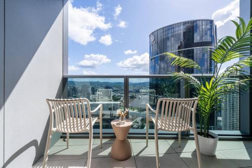 a balcony with two chairs and a view of a city at 1Bedroom Apt with Sofa bed in Queen's Wharf BNE - Lv 33 in Brisbane