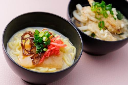 two black bowls of soup with vegetables and noodles at Hakata Tokyu REI Hotel in Fukuoka