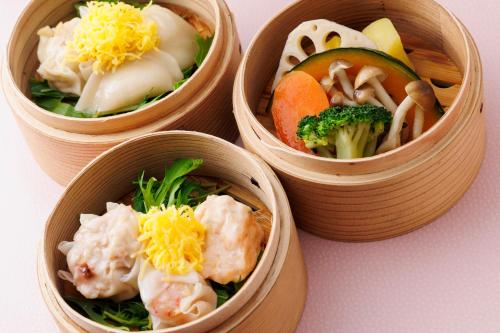 four wooden bowls filled with different types of food at Hakata Tokyu REI Hotel in Fukuoka