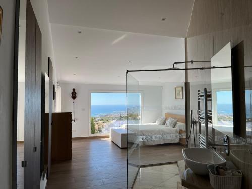 a bedroom with a bed and a bathroom with a sink at Villa Eirini Kamares Tala Luxury Sea View in Tala