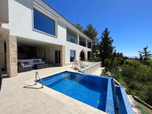 a swimming pool in front of a house at Villa Eirini Kamares Tala Luxury Sea View in Tala