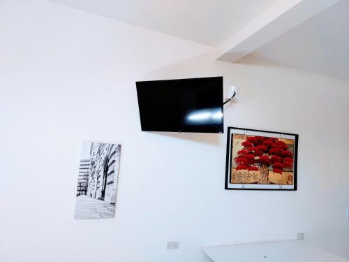 a tv on a wall with two pictures on it at Departamento 22,cerca del CAS , CIMA, CRIT, consulado,Galerias mall y centro de gobierno in Hermosillo