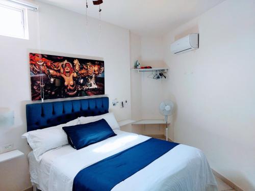 a bedroom with a large bed with a blue headboard at Departamento 22,cerca del CAS , CIMA, CRIT, consulado,Galerias mall y centro de gobierno in Hermosillo