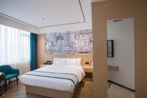 a hotel room with a bed and a blue chair at City Comfort Inn Luzhou Jiangyang District Wancheng International in Luzhou