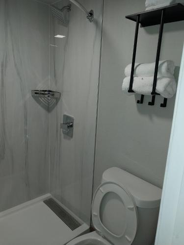 a bathroom with a shower and a toilet and towels at Gateway Inn in Graham