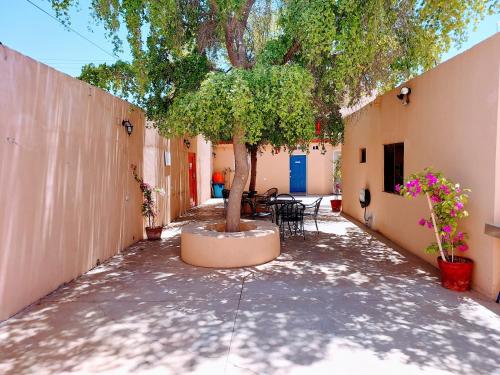 a courtyard with a tree and tables and chairs at Departamento 22,cerca del CAS , CIMA, CRIT, consulado,Galerias mall y centro de gobierno in Hermosillo
