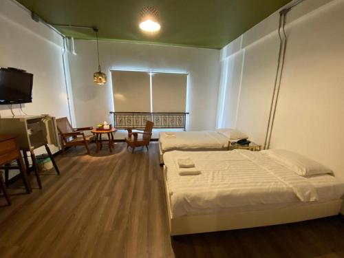 a bedroom with two beds and a table and a television at Me Design khao yai in Mu Si