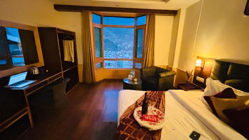 a hotel room with a bed and a desk and a window at Ocean Dreams & Hotel Meadows Dream ! Bikers,Couple & Family Hotel ! Valley View ! Open Terrace Cafe in Manāli