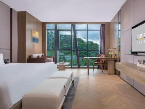 AMIGO migo Sleeping Hotel (mission hills) في Tiantangwei: غرفة فندقية بسريرين وتلفزيون