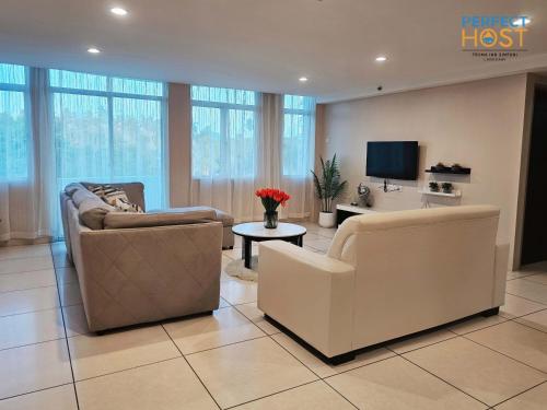 a living room with two couches and a tv at Triima Inn Dayang Bay by Perfect Host in Kuah