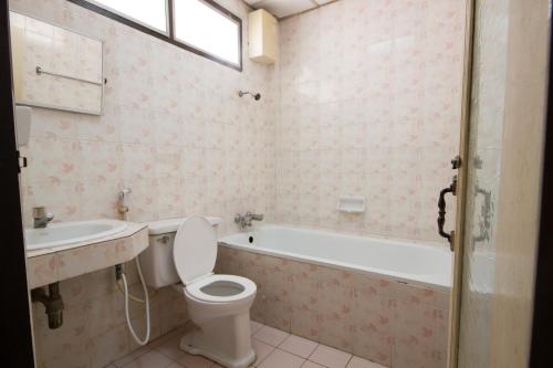 a bathroom with a toilet and a tub and a sink at Bualuang HOTEL in Ang Thong