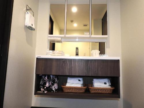 a bathroom with a sink and a counter with baskets at Hotel Bougainvillea Minowa in Tokyo