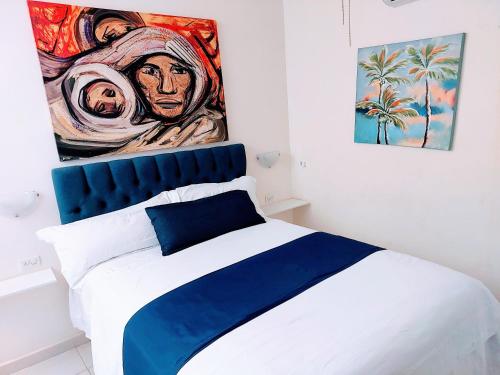 Un dormitorio con una cama con un cuadro en la pared. en Loft 25 excelente y comodo, cerca del vado del rio, consulado,CAS, galerias mall , cama queen , cocineta, en Hermosillo