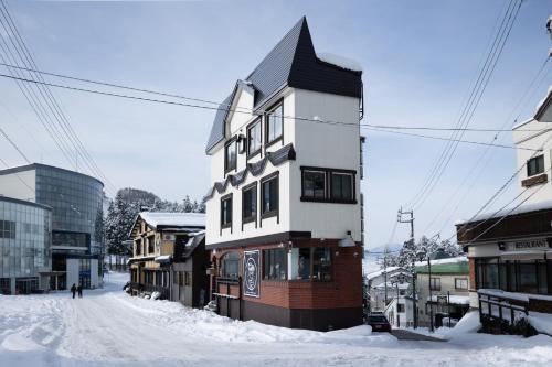 a building on a street with snow on the ground at Address Nagasaka in Nozawa Onsen