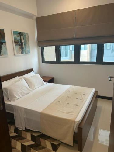 a bedroom with a large white bed with a window at Colombo, Trizen Luxury Apartments, Sri Lanka in Colombo