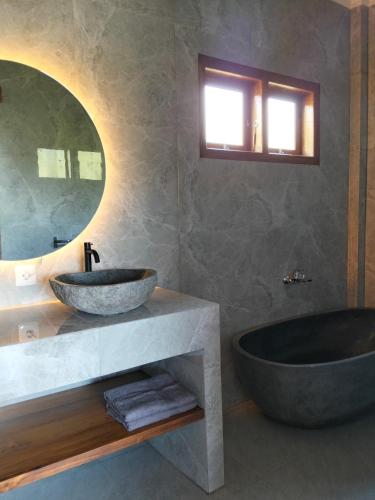 a bathroom with a large sink and a tub at MMMpulukansurfvilla in Medewi