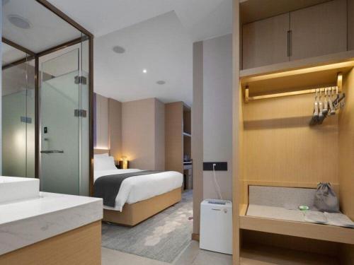 a hotel room with a bed and a bathroom at Lavande Hotel Guangzhou Quzhuang Metro Station in Guangzhou