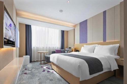 a hotel room with a large bed and a table at Lavande Hotel Guangzhou Quzhuang Metro Station in Guangzhou