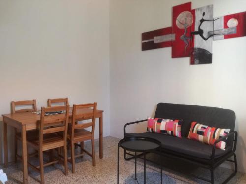 a living room with a table and chairs and a couch at Appartamento in centro con terrazza in Viareggio