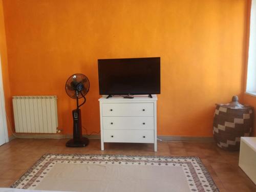 a living room with a television on a white dresser at Appartamento in centro con terrazza in Viareggio