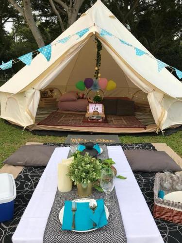 a tent with a table in front of it at Glamping kaki singapore-Standard medium bell tent in Singapore
