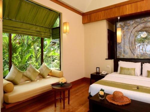 Un dormitorio con una cama y una ventana grande. en Baan Talay Dao Resort, en Hua Hin