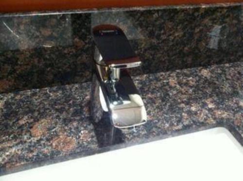 a cell phone in a holder on a counter at Pacific Motor Inn in San Jose