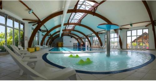 une piscine dans une salle de sport avec des chaises et une grande salle dans l'établissement Mobil-home grand confort - Camping siblu la reserve, à Gastes