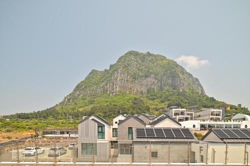 a mountain with solar panels in front of a city at Masion Sanbang Jeju in Seogwipo