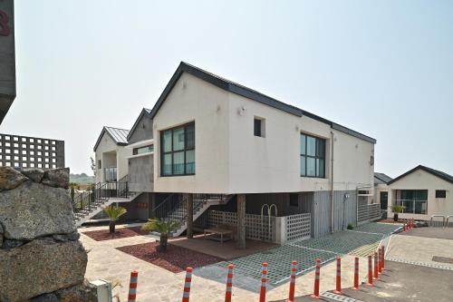 a large white house with a lot of windows at Masion Sanbang Jeju in Seogwipo