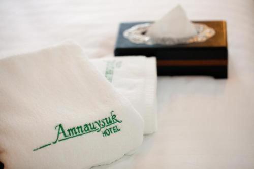Ban Si ThanにあるAmnauysuk Hotelのテーブルの上に白いタオルが敷かれたテーブル