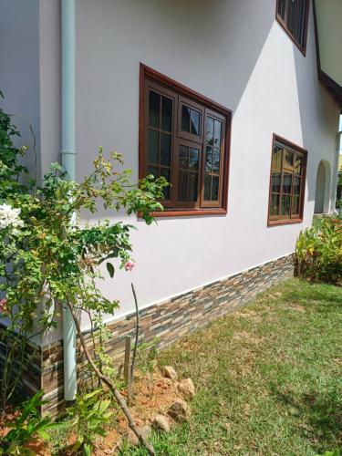 a house with a window and a yard at La Banane Rouge Self Catering in La Digue