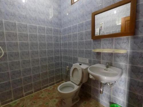 un baño con inodoro y lavabo en Chiangsan Goldenland Resort, en Chiang Saen