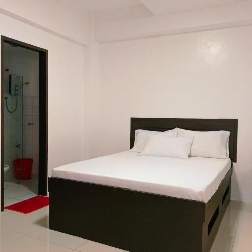 a bedroom with a large bed with a shower at The Strand Suites and Dormitel in Davao City