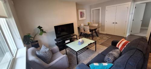 a living room with two couches and a television at Happy Zone Suite with AC - Sleeps 4, Free Treats ! in Langford