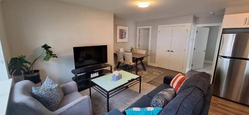 a living room with a couch and a tv at Happy Zone Suite With AC- Sleeps 4- Free Welcome Snacks and Drinks ! in Langford
